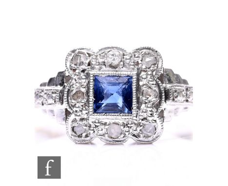 An early 20th Century 18ct and platinum sapphire and diamond cluster ring, central square sapphire to a eight stone diamond s