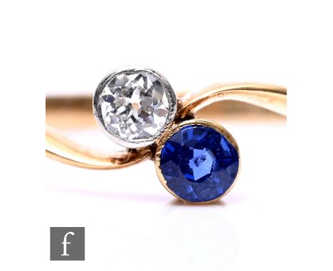 An 18ct diamond and sapphire two stone cross over ring, collar se stones, weight 2.5g, ring size M.