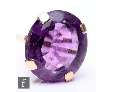 A 9ct single stone amethyst ring, oval stone, length 24mm, to a plain shank, weight 11.5g, ring size J.