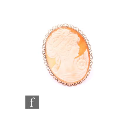 A later 20th Century 9ct gold shell cameo, carved with female in profile, on a scroll 9ct gold surround and supported by pin 