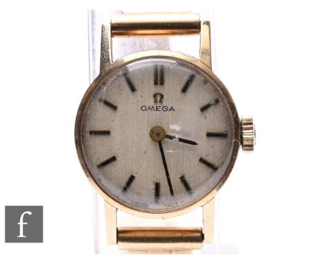 A lady's 9ct hallmarked Omega manual wind wrist watch, batons to a circular dial, case diameter 20mm, to a 9ct brick bracelet