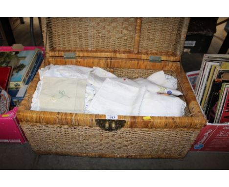 A wicker and string work storage trunk and contents of various linen and lace