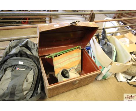 A metal storage trunk, a small metal folding garden chair, watering can etc.