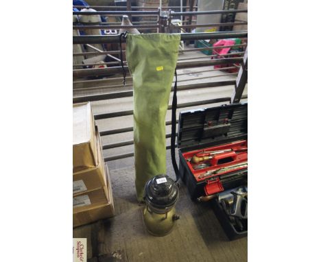 A folding camp chair in bag and a hanging oil lamp