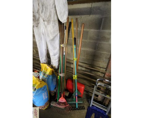 A quantity of long handled garden tools to include rakes, brushes, hoes, shovels etc. 