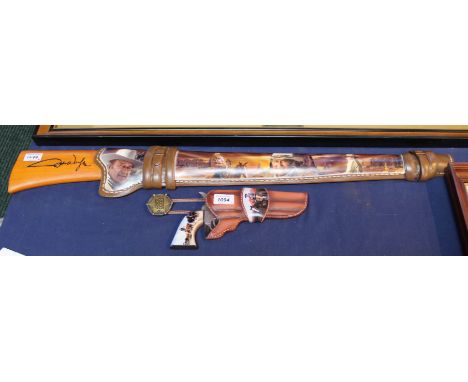 A ceramic 'Bradford' collectable John Wayne revolver in holster and a Winchester rifle in saddle scabbard