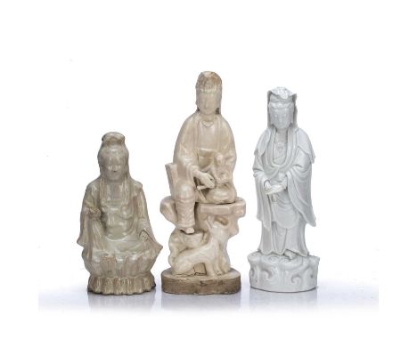 Three Dehua figures of GuanyinChinese, 19th centurycomprising of a standing figure, her arms together at the centre standing 
