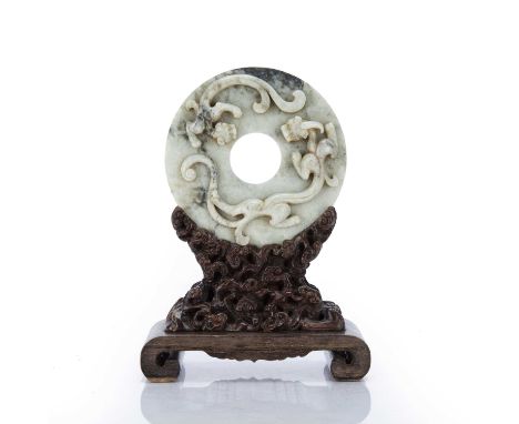 Jade archaic style discChinese, Eastern Zhou stylethe disc carved with chi-lin dragons, on a carved wooden stand of ruyi and 