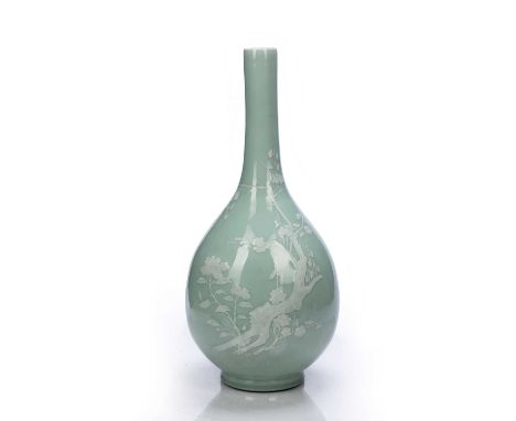 Celadon bottle vase Chinese,18th/19th Centurydecorated in white slip depicting a flowering tree growing from a rocky outcrop,