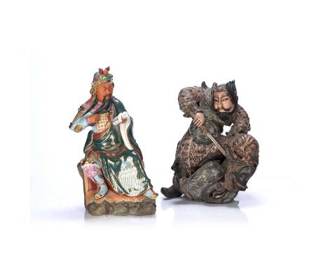 Two guardian figuresJapanesecomprising of a ceramic figure holding a book to the hand while holding his beard, 36cm high and 