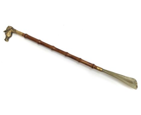 A horn, bamboo and gilt metal shoe horn the terminal in the form of a horse's head with jockey's cap, 53cmL 