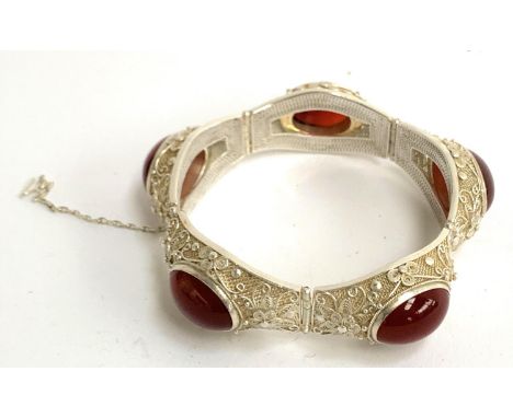 An early 20th century Chinese export silver filigree bracelet set with carnelian cabochons, with safety chain, the clasp stam