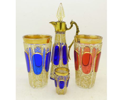 Two Bohemian drinking glasses, a similar small liqueur decanter with gilt metal mount and a small glass, (4), glass rim of de