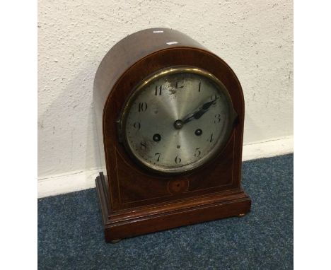 A mahogany inlaid clock with silvered dial. Est. £20 - £30.