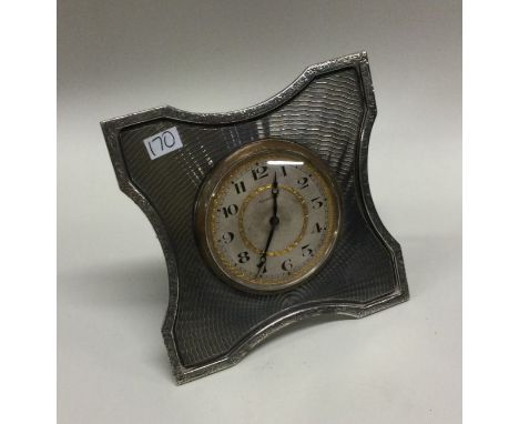A large heavy silver desk clock with engine turned decoration. London 1925. By Goldsmiths &amp; Silversmiths. Approx. 306 gra