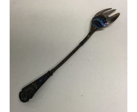 A Continental silver gilt and enamelled pickle fork. Approx. 24 grams. Est. £20 - £30.