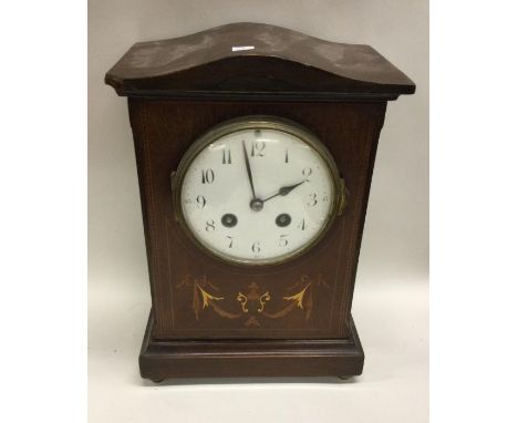A mahogany inlaid mantle clock. Est. £20 - £30.
