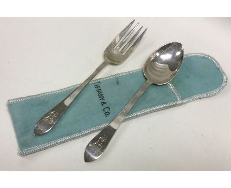 TIFFANY &amp; CO: A silver christening knife and fork in sleeve. Approx. 79 grams. Est. £100 - £150.