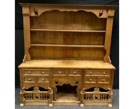 A 20th century French style pine kitchen dresser, swallow cut two shelf back above deep base fitted with an arrangement of ei