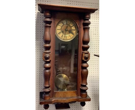A Vienna wall clock, enameled chapter ring, Roman numerals, glazed door, flanked by turned pilasters 