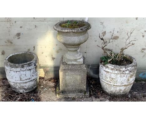 A reconstituted stone planter on stand and two reconstituted stone barrel shaped planters. (3)This lot must be collected from