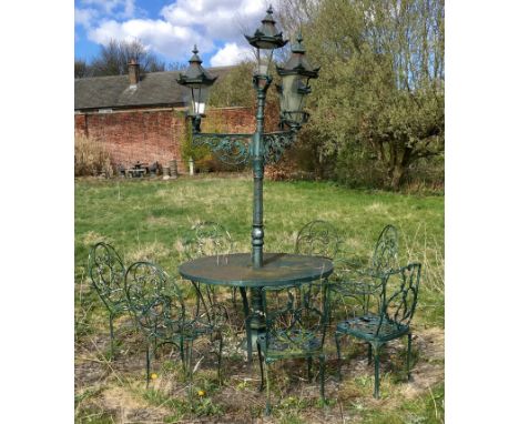 A cast iron four light garden lamp with table, five wrought iron chairs and two others, cast metal. (9)This lot must be colle