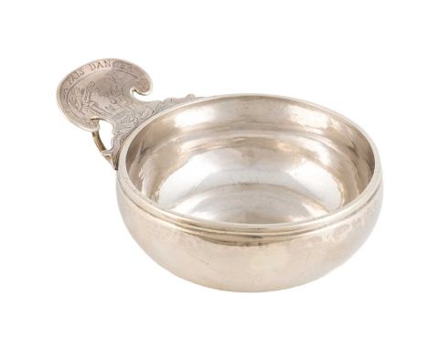 A Louis XV French silver wine taster, marks worn circa 1740, circular form, the shaped scroll thumb-piece engraved with a lad
