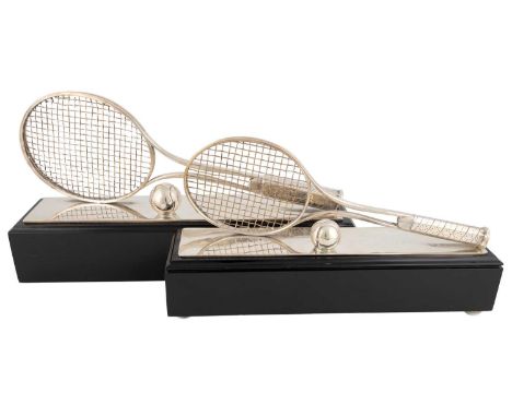 Two silver-plated tennis trophies, unmarked,modelled as tennis rackets on their sides with a tennis ball in front, both on pa