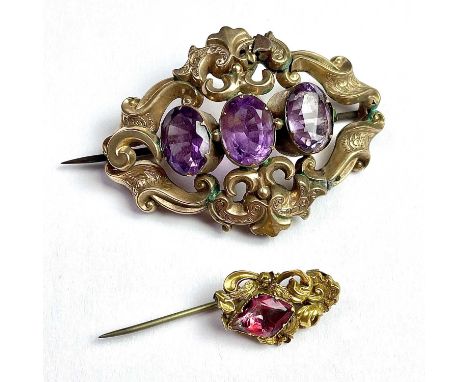 A Victorian 9ct gold three stone amethyst set brooch, with damages, width 54mm; together with a gold and paste set stick pin 