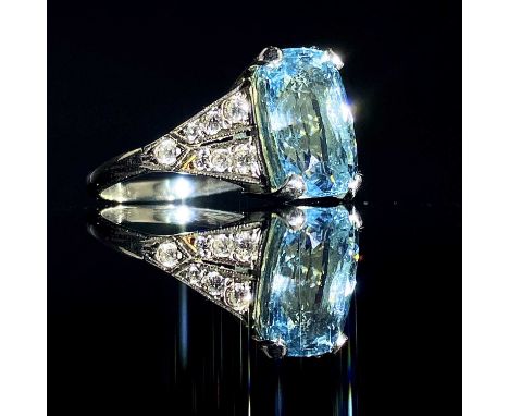 A platinum aquamarine diamond ring, the cushion cut aquamarine measures 3.5ct approximately and with 14 small diamonds to the