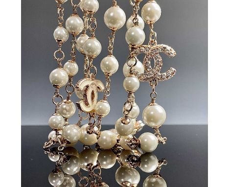 A Chanel rose gold plated, white enamel and paste set long necklace with cultured pearls, original box, length 140cm.Conditio