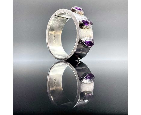 A Mexican heavy sterling 925 hinged bangle by Talleres De Los Ballesteros, set with three teardrop shaped amethyst cabochons,