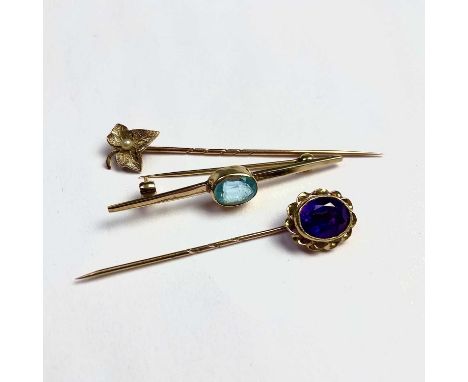 Two gold tie pins, one set with an amethyst, and a 9ct hallmarked bar brooch set with a blue stone, weight 5.7g (3)