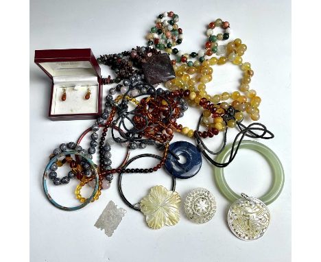 Costume jewellery including a jadeite bangle and amber beads.