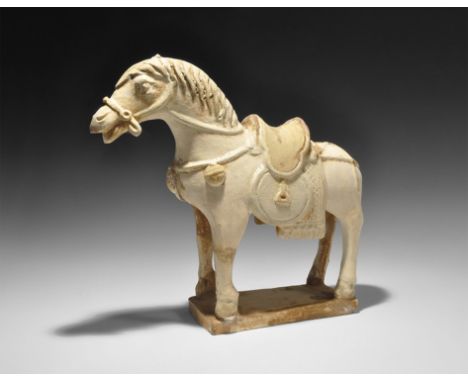  Ming Dynasty, 1368-1644 AD. A white-slipped buff ceramic statuette of a sturdy horse standing on a rectangular base with bri