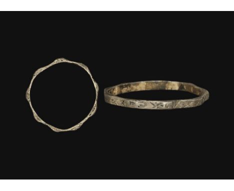  14th-15th century AD. A flat-section narrow silver hoop with nine flat panels, each bearing an incised sigil (starburst, alp