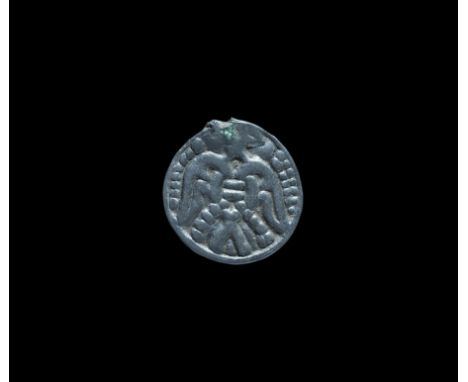  11th century AD. A large Scandinavian type pendant with raised border, image of a bird with splayed wings, pellets to the bo