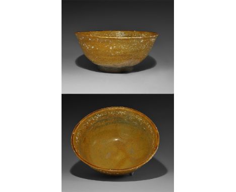  17th-18th century AD. A provincial broad ceramic bowl with flared foot and everted rim, amber-coloured glaze to both faces. 