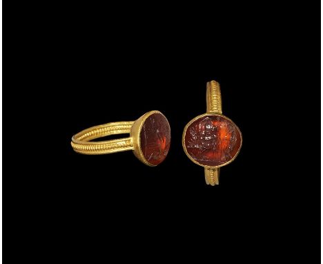  1st-3rd century AD. An inset carnelian cloison intaglio of a man, probably Jason, ploughing with two bulls, temple or palace