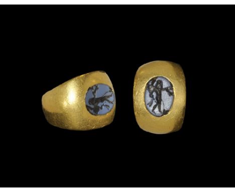  3rd century AD. A flat-section gold hoop with expanding shoulders, flat plaque with inset blue glass cloison with drunken He