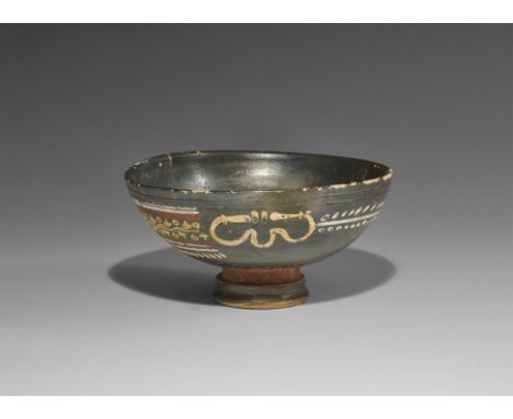  4th century BC. A ceramic blackware bowl with pedestal foot, ochre-coloured painted loop motifs, panel of ivy leaf tendrils 