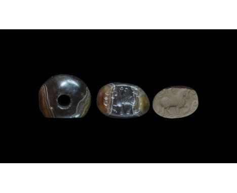  4th-6th century AD. An annular agate stamp seal with one flat face, intaglio motif of a pegasus advancing with text above; s
