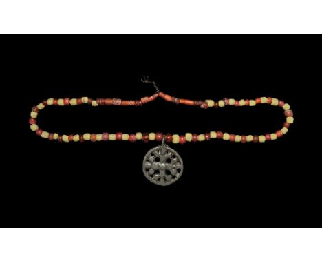  11th-13th century AD. A restrung necklace of mainly spherical glass beads in shades of yellow and orange, openwork silver co