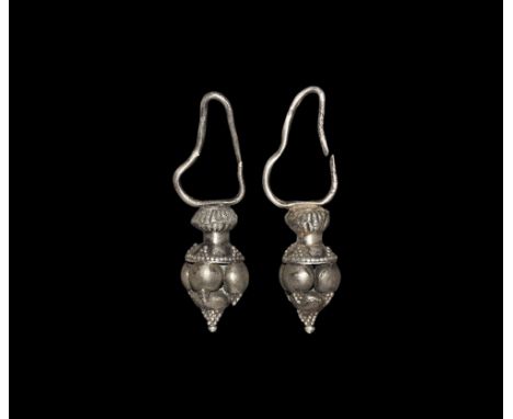  7th century AD. A matched pair of silver earrings, each a pyramid of hollow balls with biconical bulb, granule detail and th