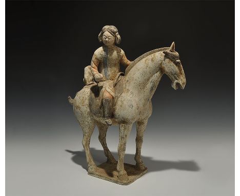  Tang Dynasty, 618-906 AD. A ceramic horse on a small base with patches of mottled brown paint on the body and darker brown p