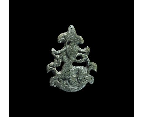  11th-12th century AD. A flat-section triangular openwork mount formed as an advancing lion in a mesh of scrolled fronds and 