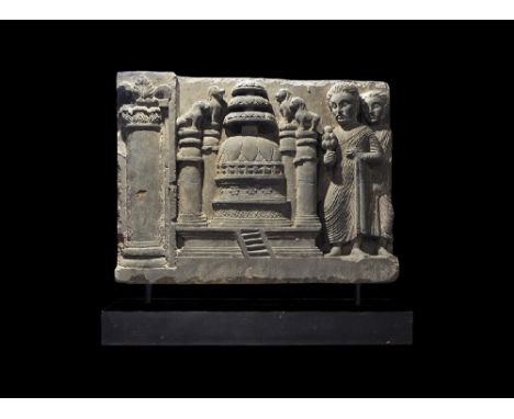  2nd-4th century AD. A carved schist rectangular frieze with foliage-headed column to the left edge; stupa with tiered base a