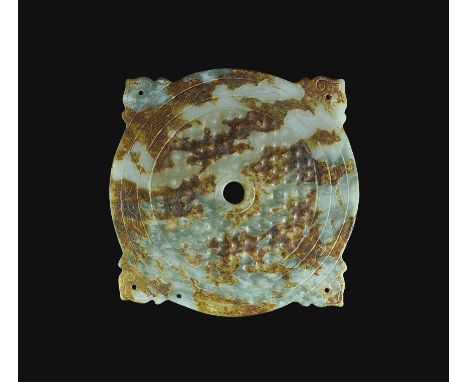  19th-20th century AD. A bifacial jadeite discoid plaque with four exterior pierced lugs, volute scrolls to the lugs; to each