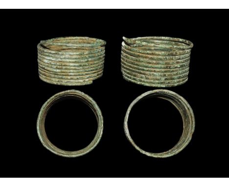  800-500 BC. A pair of coiled bracelets each formed from a continuous rod in ten passes with ribbed texture to the outer face