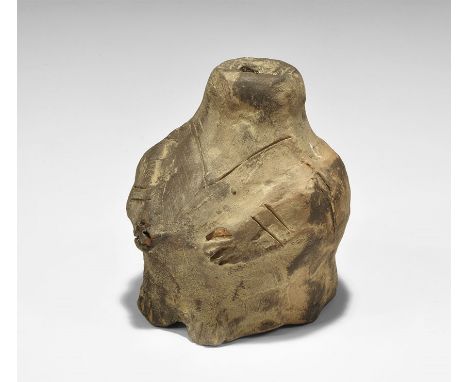  Neolithic, 6th-5th millennium BC. A greyware ceramic figurine modelled in squatting posture with arms to the chest; incised 